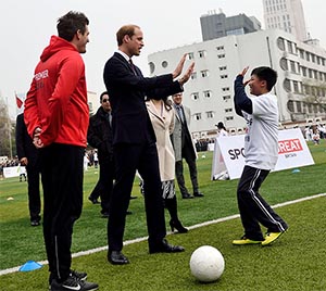 Prince William with a Chinese kid playing football